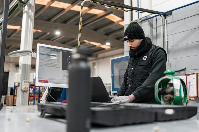 Technician using diagnostic software at an industrial workstation.